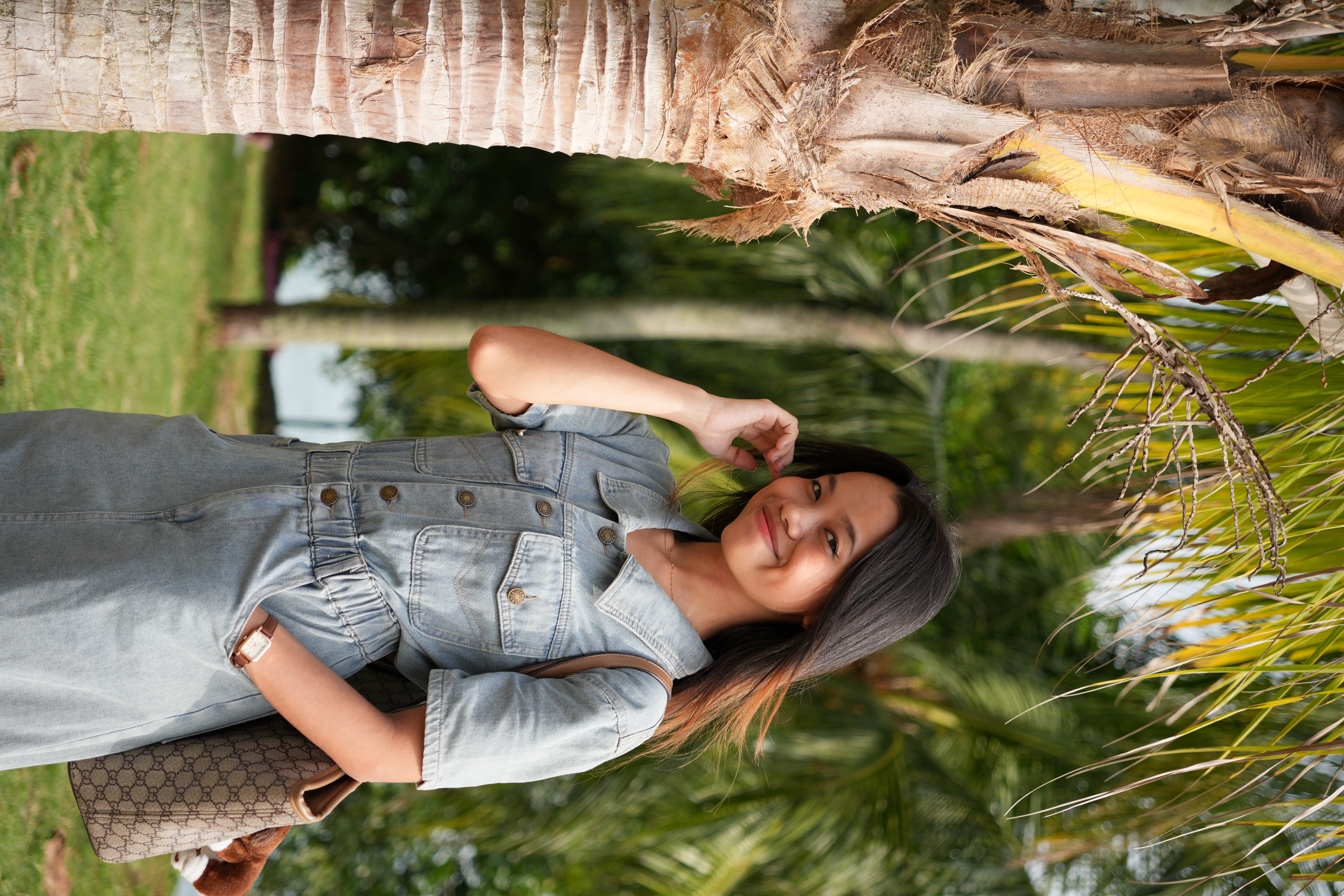 Image of model standing next to a palm tree