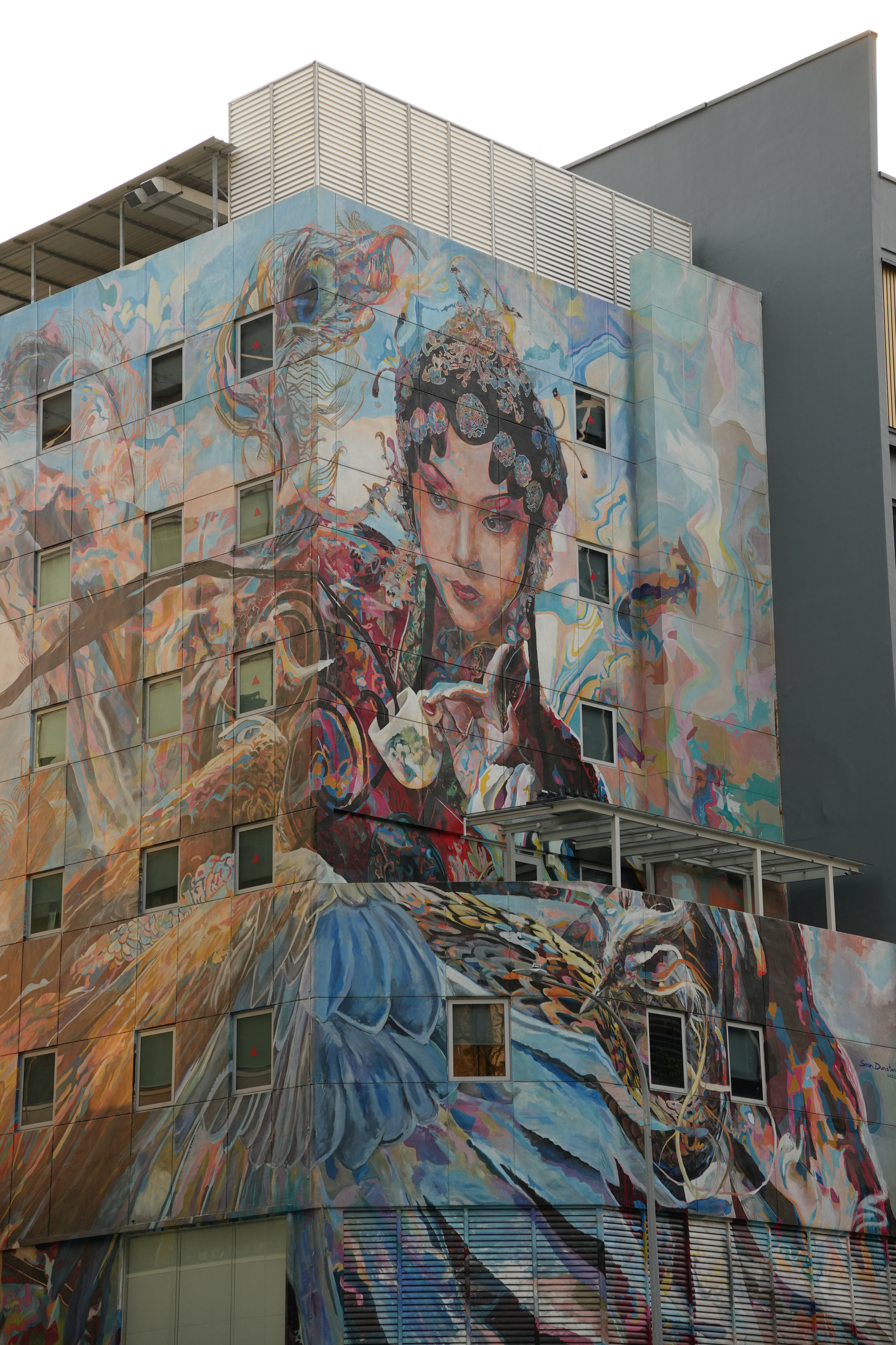 Mural of a bird-human on the front of a building in Singapore